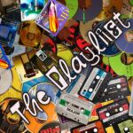 This week's theme specific artwork, courtesy of Troggie. It's a jumbled pile of CDs, MiniDiscs, and cassettes, all brightly coloured. Over them is written "ThePlaylisst"